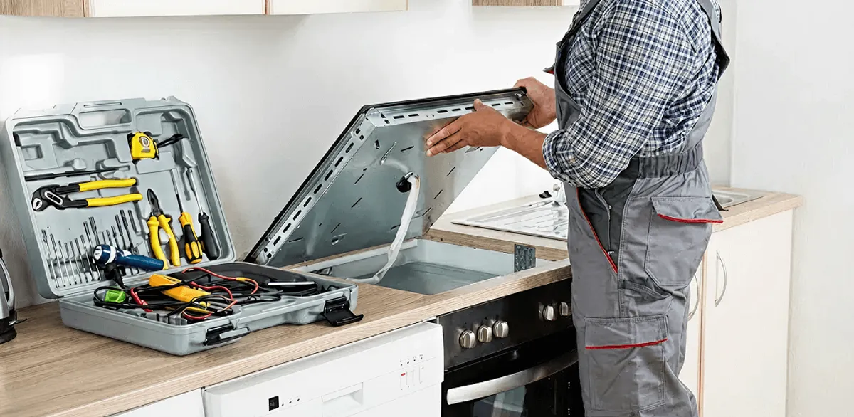 Handyman repairing a cooktop and checking wiring connections in Newark, NJ